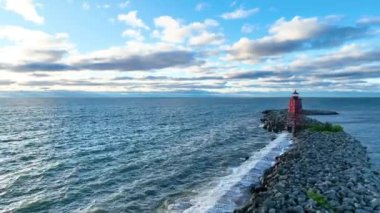 Hava sahasında güneş doğarken Michigans Gölü 'nün derin mavi sularına karşı canlı kırmızı Racine Breakwater Deniz Feneri. Sabahın erken saatlerinde sakin ol ve nazik dalgalar dinamik güzelliği artırır.
