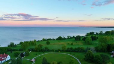 Racine Wisconsin 'de gün batımında Windpoint Deniz Feneri' nin hava manzarası. Kırmızı çatılı beyaz kule yemyeşil bir zemin ve dingin Michigan Gölü 'nün karşısında duruyor. Huzurlu bir ortam yaratıyor.