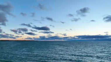 Pan Shot: Gündoğumunda Michigan Gölü 'nün havadan görünüşü, Racine, Wisconsin' i gösteriyor. Huzurlu sabah gökyüzü ve hafif dalgalar sakin bir ortam yaratır, gölün ve gölün muazzam güzelliğini yakalar.