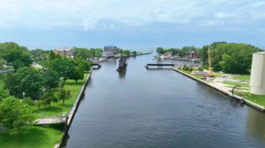 Serene St. Joseph, Michigan, sakin nehir suları üzerinde ikonik Swing Köprüsü, yemyeşil parklar, endüstriyel silolar ve parçalı bulutlu bir gökyüzü altında kentsel cazibe. İdeal