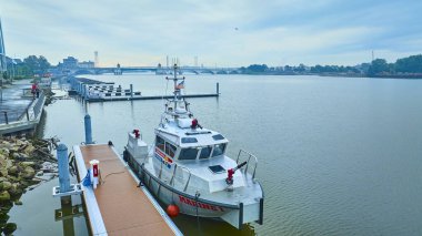 Toledo marinasındaki sakin sular, acil durum botu Marine 1 'i çerçeveletiyor. Harekete geçmeye hazır olan bu gemi şehrin simgesel köprüsü altındaki şehir yaşamını ve güvenliğini yansıtıyor. Deniz sahneleri için mükemmel..