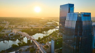 Gün doğumunda Nashville şehir merkezindeki hava manzarasında ikonik Koreli Gaziler Anıt Köprüsü gökdelenleri ve sakin bir nehri yansıtıyor ve kentsel gelişimin ve bağlanabilirliğin özünü yakalıyor..