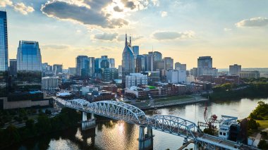 Simgesel Batman Binası, John Seigenthaler Pedestrian Köprüsü ve Cumberland Nehri ile Nashville 'in altın saatindeki hava manzarası şehirleri canlı ama sakin kent cazibesini yansıtıyor..