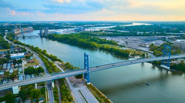 Gün batımında Maumee Nehri 'ni kaplayan Toledo Anthony Wayne Köprüsü' nün havadan görüntüsü. Altın saat ışığı bu canlı Ohio şehrindeki banliyö ve endüstri dengesini vurguluyor..