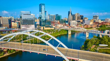 Nashville ufuk çizgisinin canlı hava manzarasında ikonik gökdelenler, sakin Cumberland Nehri ve çarpan Koreli Gaziler Anıtı Köprüsü kentsel büyüme ve manzaralı güzellikler sergileniyor..