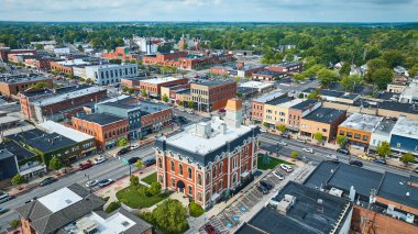 Aerial view of Defiance, Ohio highlights the historic Defiance County Courthouse, embracing small-town charm with vibrant downtown life and lush green surroundings. Perfect for tourism and community clipart