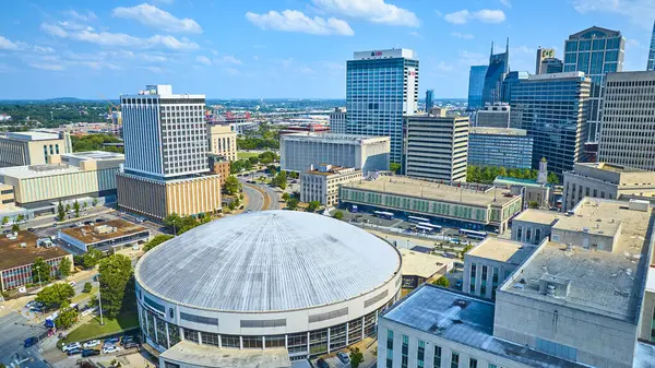 stock image Vibrant aerial view of downtown Nashville featuring the iconic Bridgestone Arena and bustling streets. The skyline blends modern and classic architecture under a clear blue sky. Perfect for urban and