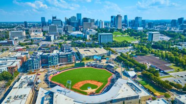 Vibrant aerial view of Nashville featuring First Tennessee Park baseball stadium nestled in a bustling urban skyline, capturing the sunny charm of Tennessees sports and city culture. clipart