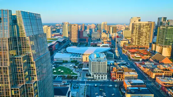 Altın saat boyunca Nashville 'in havadan görünüşü sembolik Bridgestone Arena' sını ve şehir merkezini gösteriyor. Batan güneşin altında parlayan modern gökdelenleri yakalıyor, şehir cazibesini vurguluyor ve