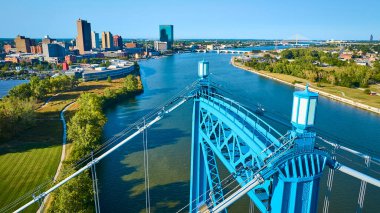 Maumee Nehri 'ni kaplayan ikonik mavi Anthony Wayne Köprüsü ile Toledo' nun canlı gökyüzü manzarası. Modern ve tarihi binaların bir karışımı Ohio 'da kentsel büyüme ve doğal güzelliği vurguluyor.