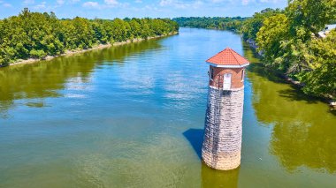 Nashville 'deki sakin bir nehirde Tennessee Omohundro Su İşleri Işık Feneri' nin hava manzarası. Bereketli ağaçlarla çevrili ve berrak mavi gökyüzünün altında bu manzara, dingin doğal güzellikleri yakalar.