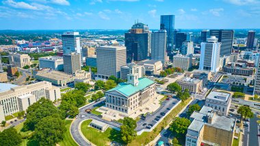 Nashville şehir merkezinin canlı hava manzarası, TN. Tarihi Tennessee Eyalet Meclisi, modern gökdelenlerin arasında, açık mavi gökyüzü altında, gelenek ve gelişimin karışımını sembolize ediyor..