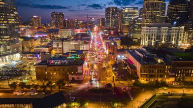 Nashville gece hayatının enerjisini yukarıdan hisset. Broadway Caddesi 'nin havadan görünüşü alacakaranlık gökyüzü altında parıldıyor. Tennessee' nin dinamik özünü yakalıyor.