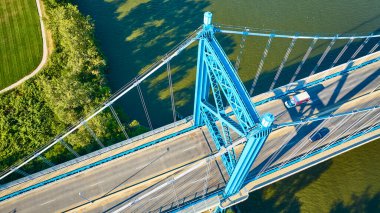 Ohio 'daki Maumee Nehri üzerindeki Toledo Anthony Wayne Köprüsü' nün havadan görüntüsü. Bu canlı mavi süspansiyon köprüsü, kentsel yaşamı doğayla zarif bir şekilde bağlar, mühendisliği ve doğal uyumu ön plana çıkarır..