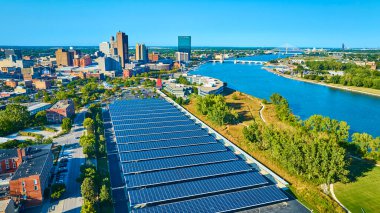 Toledo Ohio 'nun hava görüntüsü, sürdürülebilir enerjiyi vurgulayan güneş panelleriyle canlı bir ufuk çizgisi gösteriyor. Modern altyapı ve yeşil alanların karışımı kentsel planlama ve bağlantıyı yansıtır.
