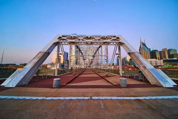 Stock image Golden hour casts a warm glow on the John Seigenthaler Pedestrian Bridge in Nashville. The robust steel design leads to a vibrant skyline, merging industrial strength with urban elegance.