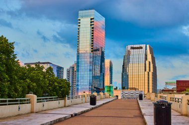 Altın saat, yükselen gökdelenlerden yansıyan güneş gibi Nashville ufuk çizgisini resmediyor. Yaya bir köprü kentsel büyümeye öncülük eder, modernliği Tennessee şehir merkezindeki doğayla harmanlar..