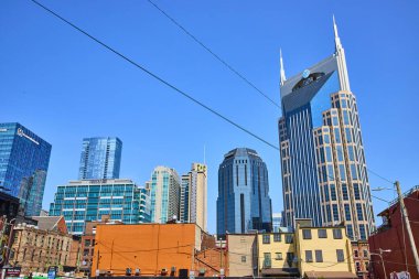 Nashville şehir merkezi gökdelenleri ve ikiz kuleleri ile açık mavi gökyüzü altında göz kamaştırıyor. Modern yüksek binalar ve tarihi binalar harmanlanarak, canlı şehir enerjisini yakalıyorlar.