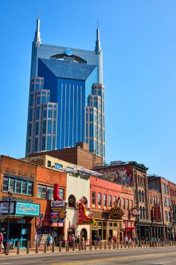 Nashville 'deki Broadway Caddesinde canlı neon ışıkları ve tarihi barlar var. İkonik Batman Binası açık mavi gökyüzüne karşı dimdik duruyor, müziğin eşsiz bir harmanını yakalıyor ve...