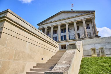 Majestic Tennessee Eyalet Meclisi Nashville 'de açık mavi bir gökyüzünün altında dimdik duruyor. Neoklasik mimari ve Amerikan bayrağı otorite ve miras yayar. Yönetim temaları için mükemmel