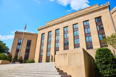 Majestic Tennessee State Office Building in Nashville stands tall under a clear blue sky. Its classical design with stately columns and the American flag capture the essence of governance and civic clipart