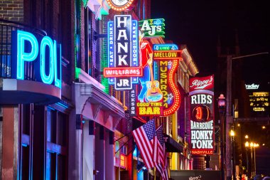 Nashville 'deki Broadway Caddesi' nin canlı gece hayatını yaşayın. Neon tabelalar AJ Good Time Bar ve Rippys Ribs gibi ünlü barları aydınlatır. Tennessee 'de canlı bir müzik ve eğlence merkezi.