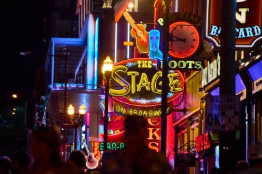 Neon ışıkları Nashville, Tennessee 'de Broadway' i aydınlatıyor, canlı müzik mekanları ve elektrikli bir gece hayatı sergiliyor. Broadway tabelasındaki ikonik sahne ışıl ışıl parlıyor, kalabalıkları bu canlı şehre çekiyor.