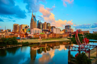 Simgesel Batman Binası ve Hayalet Bale Heykeli ile nefes kesici Nashville silüeti. Cumberland Nehri, Tennessee şehir merkezindeki tarih ve modernliğin canlı bir karışımını yansıtır.