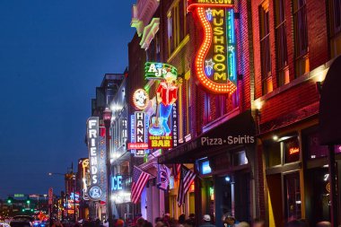 Nashville 'deki Broadway Caddesi' nin heyecan verici gece hayatını yaşayın. Neon işaretleri alacakaranlık gökyüzüne karşı parlıyor, sizi canlı barları ve bu ikonik eğlence mekanlarında canlı müzik mekanlarını keşfetmeye davet ediyor.