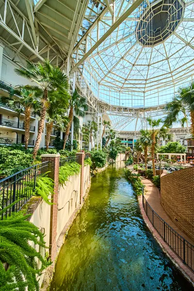 Experience tranquility at Gaylord Opryland lush indoor atrium. Stroll along the winding river, surrounded by vibrant tropical plants beneath a stunning glass ceiling. Perfect for a luxury escape.