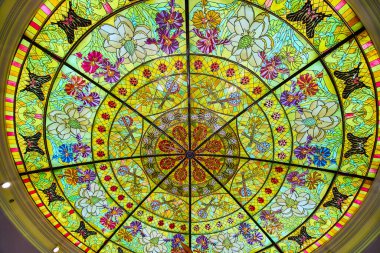 Stunning stained glass ceiling at Gaylord Opryland in Nashville showcases vibrant floral design with yellow, green, red, purple, and blue hues. A masterpiece of artistry and heritage in a historic clipart