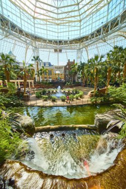 Escape to a lush tropical paradise in the heart of Nashville. This vibrant atrium at Gaylord Opryland features a stunning waterfall and European-inspired architecture under a grand glass ceiling.