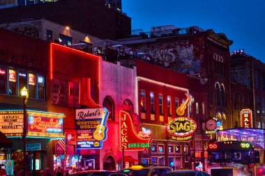 Nashville 'deki Broadway Caddesi' nin canlı gece hayatını yaşayın. İkonik honky-tonk barlarının parlak neon işaretleri sahneyi aydınlatıyor, canlı Tennessee 'nin müzik dolu ruhunu yakalıyor.