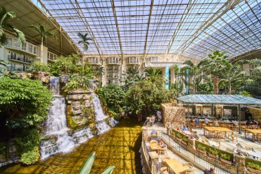 Experience the serene luxury of Gaylord Opryland tropical atrium in Nashville, where lush greenery and a magnificent indoor waterfall create a tranquil oasis for relaxation and leisure.