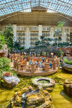 Experience luxury and relaxation at Gaylord Opryland in Nashville. Enjoy a serene brunch amidst lush tropical plants, tranquil water features, and natural light in a stunning indoor atrium.