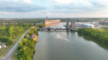 Aerial Fly: Glass City Duvarı duvar resmi, akan Maumee nehri ve tren köprüsünün altın saatindeki endüstriyel cazibesiyle Toledo 'nun canlı ruhunu keşfedin..