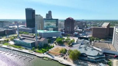 Hava İzleme Çekimi: Toledo Nehir Önü ve Ufuk Çizgisi 'ni Deneyin. Tanınmış KeyBank ve ProMedica kuleleri, berrak mavi bir gökyüzü altında, kentsel gelişim ve doğal güzelliği gözler önüne seren,.