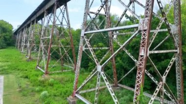 Pedestal Shot: Nashvilles tarihi tren köprüsünün havadan görünüşü ile endüstri ve doğanın karışımını keşfetmek, kırsal çelik dizaynını berrak bir zemin altında yemyeşil bir yemyeşil zemine karşı sergilemek