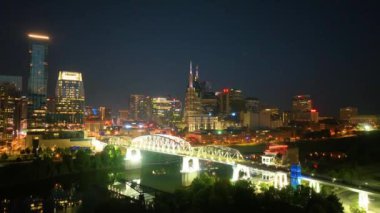 Hava Yayası Çekimi: Nashvilles 'in canlı bir siluetini, Cumberland Nehri' ni zarifçe kaplayan aydınlanmış John Seigenthaler Pedestrian Köprüsü ile yakalayın.