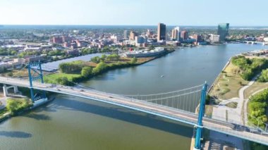 Maumee Nehri 'ni kaplayan ikonik mavi Anthony Wayne Köprüsü ile göz alıcı Toledo silueti. Canlı şehir manzarası yemyeşil nehir manzarası ile uyumlu, şehir güzelliğini gözler önüne seriyor ve...