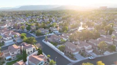 Havadan Uç: Las Vegas 'ın sakin banliyölerini altın saatinde keşfedin, bronz çatılı evler, yemyeşil ve uzak dağlar, günlük hayattan uzakta huzurlu bir bakış sunuyor