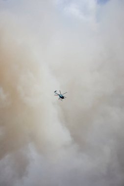 Ohio 'daki bir itfaiye operasyonu sırasında yoğun dumanların içinden bir helikopter geçiyor. Hava sahnesi, hurda metal yangınına tepki olarak aciliyet ve beceriyi vurguluyor..