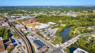 Fort Wayne, Indiana şehir merkezinin hava manzarası Gaziler Anıtı Köprüsü ve yemyeşil nehir kıyısını vurguluyor. Konutların ve tarihi binaların canlı karışımı şehir büyümesini ve kentsel doğanın uyumunu gözler önüne seriyor