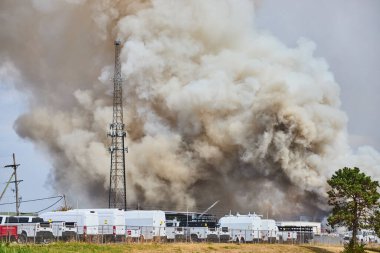 Ohio 'daki bir Kolomb Oto İmha Yangını' ndan yoğun duman bulutu yükseliyor. Acil durum araçları bu endüstriyel krize bir hurdalıkta hızla cevap vererek acil afet yönetimi çabalarını vurguluyor..