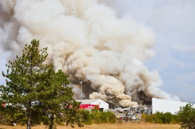 Dramatik bir endüstriyel yangın Columbus hurdalığından yoğun beyaz duman salıyor. Acil durum ekipleri, kaos ortamında tek başına ayakta duran bir ağaç gibi hızlı tepki veriyor. Odaklı çevre ve güvenlik