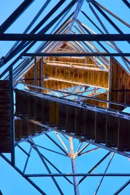 Hocking Hills Ohio 'daki Ash Cave Fire Tower' ın karmaşık tasarımına bakın. Bu ahşap ve metal mucize, gökyüzü altında geometrinin ve doğanın güzelliğini yakalar. Kaşifler için mükemmel..