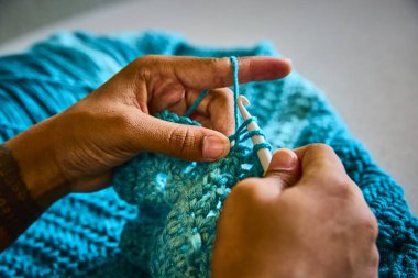 Geleneksel el işçiliğinin bu yakın çekiminde eller maharetli, canlı mavi iplik. Tığ işi sanatını ve Fort Wayne, Indiana 'daki küçük işletmelerin yaratıcılığını vurgulamak için mükemmel..
