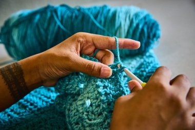 Fort Wayne Indiana 'da gelenek ve modernliği harmanlayan, Afrikalı Amerikalı bir zanaatkar, canlı turkuaz ipliğin yetenekli elleri. El sanatları ve DIY meraklıları için mükemmel.