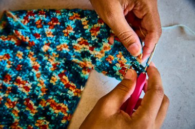 Fort Wayne, Indiana 'da yetenekli ellerin canlı ipliklerle örgü ördüğü yakın plan. Odaklanmış işçilik, küçük işletme ve DIY projelerini desteklemek için mükemmel olan el yapımı yaratıcılık sanatının altını çiziyor.