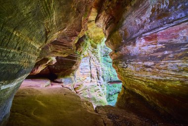 Hocking Hills, Ohio 'daki büyüleyici Rock House mağarasına adım atın. Canlı kumtaşı renklerine ve yemyeşil renklerine hayran olun. Maceranın özünü ve doğanın ebedi güzelliğini yakalayın..